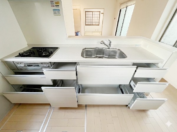 スライド収納付きのシステムキッチン。料理器具なども収納できて出し入れもスムーズ。収納量もたっぷりなので料理器具やストック調味料なども入れられる。