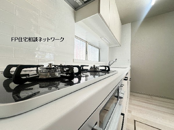 白を基調とした清潔感のあるシステムキッチン。作業スペースが広く、収納も充実しているため、毎日の料理がスムーズに。窓付きで換気もしやすい快適なキッチン空間です。