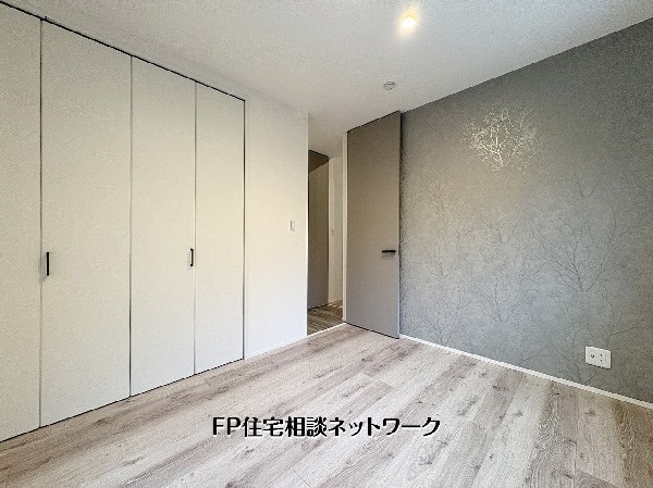 【洋室5.2帖】  アクセントクロスが空間に上質な印象を与える洋室。大型クローゼット付きで収納力も確保し、寝室や書斎など多用途に使える落ち着いた一室です。