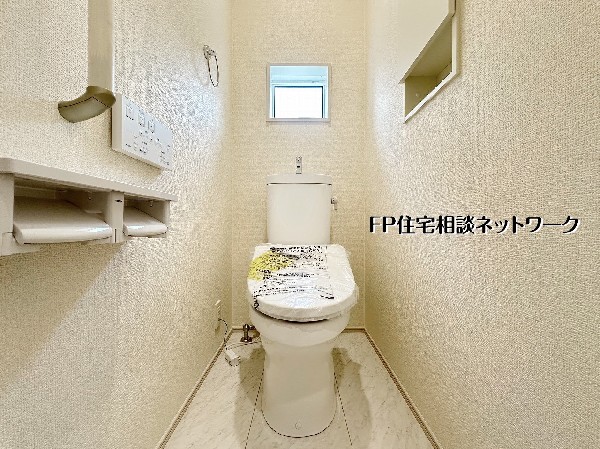 【トイレ│1階】小窓付きで明るく清潔感のあるトイレ空間。温水洗浄便座や収納棚を備え、毎日快適に使えるよう細部まで配慮された設計です。