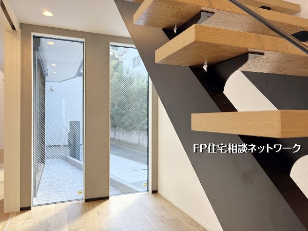 【玄関ホール】  自然光がたっぷり届く玄関ホールは、明るく迎え入れてくれる心地よい空間。デザイン階段が視線を引き、空間全体を広く感じさせる美しい設えです。