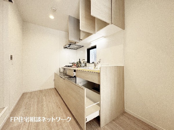 スライド収納付きのシステムキッチン。料理器具なども収納できて出し入れもスムーズ。収納量もたっぷりなので料理器具やストック調味料なども入れられる。