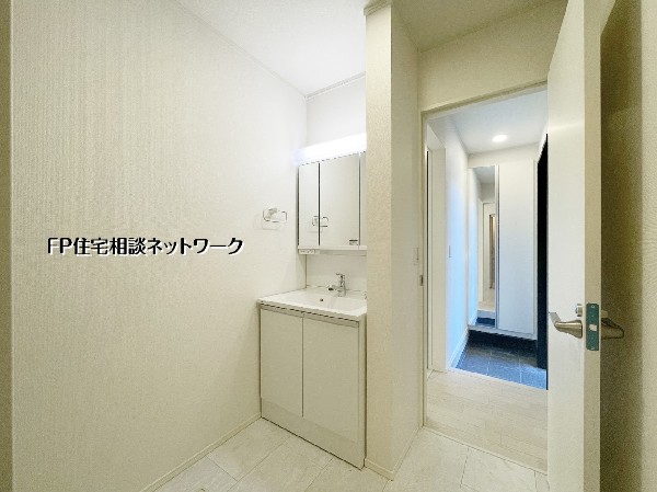 同仕様設備：玄関ホールから洗面室へ直結し、帰宅後の手洗いもスムーズ。白で統一された清潔感溢れるサニタリーは、三面鏡付きの洗髪洗面化粧台を完備。