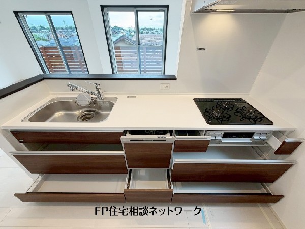 スライド収納付きのシステムキッチン。料理器具なども収納できて出し入れもスムーズ。収納量もたっぷりなので料理器具やストック調味料なども入れられる。
