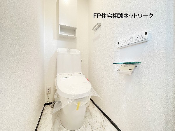 【トイレ】温水洗浄便座付きのトイレ。吊り戸棚収納も備え、日用品をスッキリとしまえる清潔感のある空間です。 