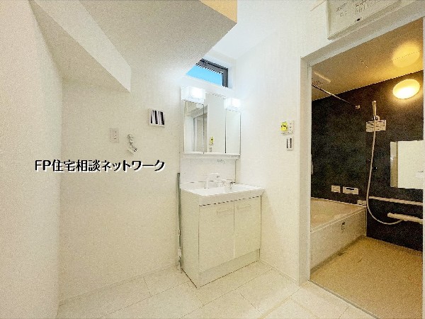 【洗面脱衣室】  洗面室は白を基調とした清潔感のある空間。三面鏡付き洗面台で身支度がしやすく、浴室と隣接した配置により朝夕の動線にも配慮されています。