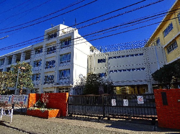 周辺環境:向丘中学校　(葵の校章です。学び合い、高め合い、ともに活きることが教育目標です。)