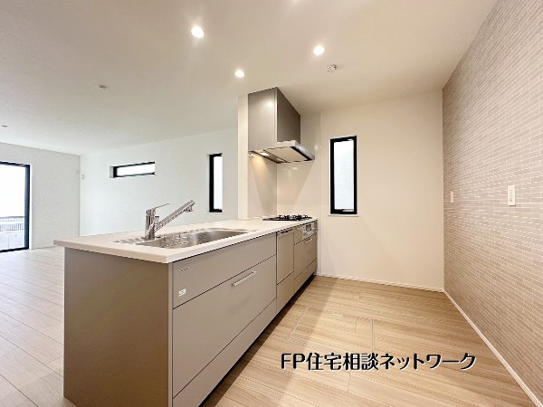 【キッチン】  ダイニング側にゆとりを確保したレイアウトで配膳もスムーズ。壁面アクセントが空間を引き締め、窓からの採光も良好。収納力も備えた実用的なキッチンです。