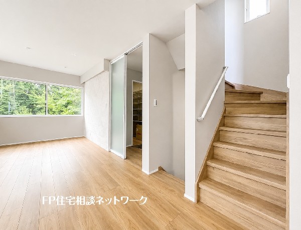 【LDK│20帖】  家族が自然と顔を合わせやすいリビング階段を採用した設計です。すりガラスの引き戸が空間に広がりを与え、大きな窓からは緑の借景を楽しめる、毎日をリラックスして過ごせる心地よいお部屋です。
