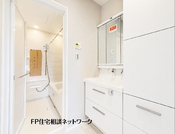 【洗面脱衣室】  白を基調とした清潔感あふれる明るい洗面脱衣室です。三面鏡裏や足元の引き出しなど豊富な収納を備えた洗面台を採用しており、小物やタオル類もすっきりと整理できる機能的な空間です。 