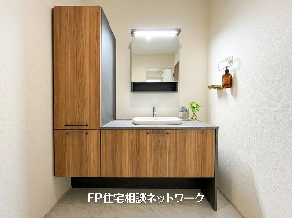 【洗面台】  落ち着いた木目調とグレーの天板が、洗練されたホテルライクな空間を演出。大容量のサイドキャビネットで収納力も抜群です。機能美とデザインが両立した洗面台で、朝の準備をより贅沢で心地よいひととき