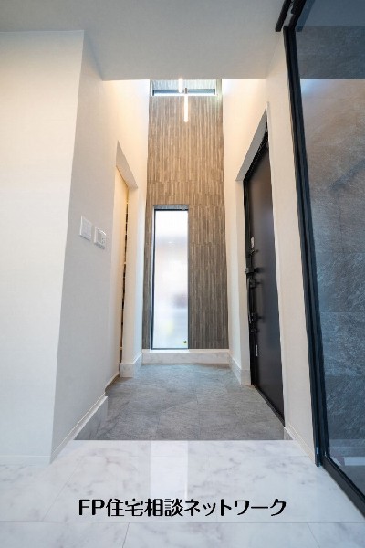 縦窓から自然光を取り込むホール空間。シンプルな意匠でまとめ、住まい全体の上質感を引き立てています。