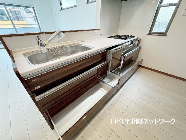 スライド収納付きのシステムキッチン。料理器具なども収納できて出し入れもスムーズ。収納量もたっぷりなので料理器具やストック調味料なども入れられる。