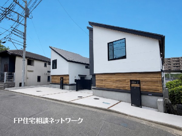 外観:【外観】  白の外壁に木目調のアクセントが映えるモダンな外観。複数台駐車が可能なゆとりあるカースペースを完備しています。洗練された新邸で、心地よい新生活を。