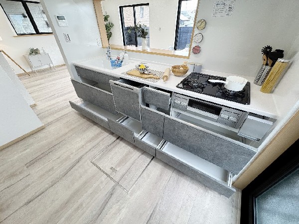 スライド収納付きのシステムキッチン。料理器具なども収納できて出し入れもスムーズ。収納量もたっぷりなので料理器具やストック調味料なども入れられる。