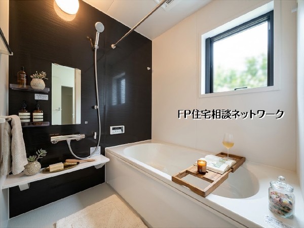 【浴室】シックな黒のアクセントパネルが高級感を演出するバスルーム。ゆったりとした浴槽に、換気や採光に便利な窓も備わっています。