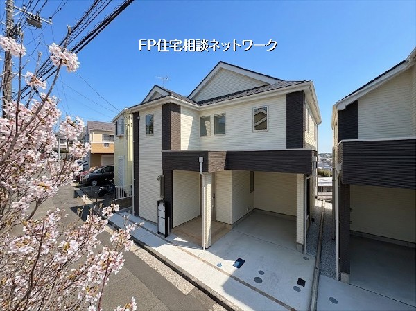 外観:【外観】  明るい日差しと満開の桜が彩る、清潔感あふれる新築住宅。機能的なビルトインガレージを備え、並列駐車も可能です。開放的な住環境で、家族の新しい物語をここから始めませんか。