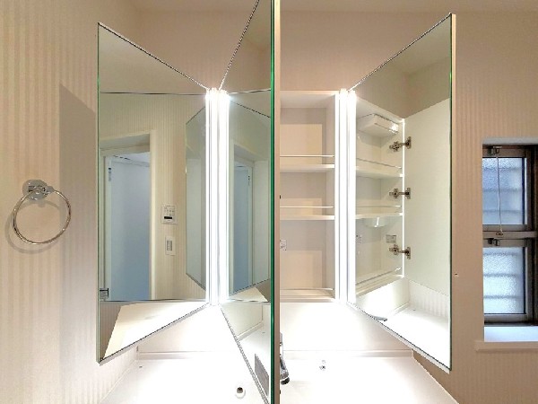 鏡の裏に豊富な収納量を確保した、三面鏡タイプの洗面化粧台。化粧品やティッシュボックス、歯ブラシなどを機能的に収納できるスペースを設えました。