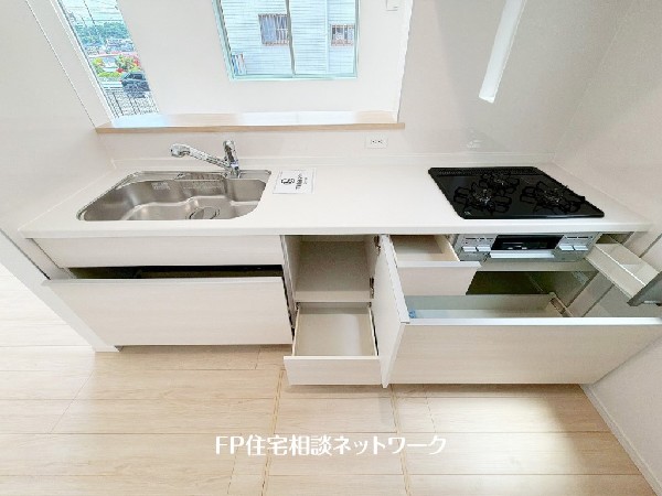 スライド収納付きのシステムキッチン。料理器具なども収納できて出し入れもスムーズ。収納量もたっぷりなので料理器具やストック調味料なども入れられる。