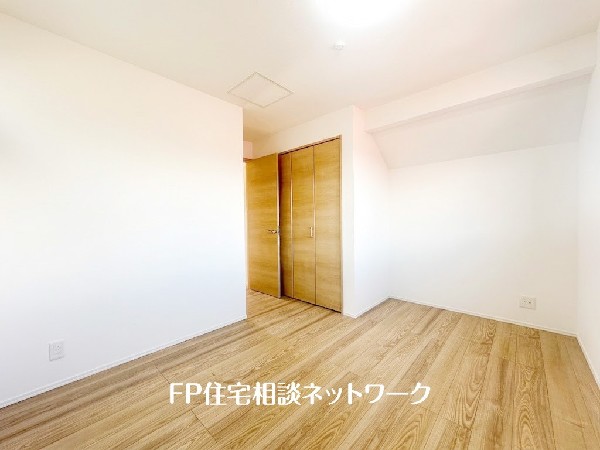 【洋室│6帖】  白を基調とした壁と、温かみのある木目調のフローリングが調和する室内。奥行きのあるクローゼットを備え、収納力も確保。清潔感のある、落ち着いた雰囲気の空間です。