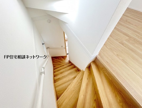 【階段】  木製の踏板が温かみを感じさせる階段。上部からの視点は、開放的な空間と下階への繋がりを感じさせます。手すりが設置され、昇降のしやすさにも配慮されています。