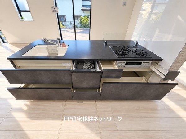スライド収納付きのシステムキッチン。料理器具なども収納できて出し入れもスムーズ。収納量もたっぷりなので料理器具やストック調味料なども入れられる。