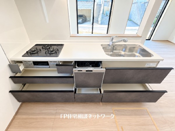 スライド収納付きのシステムキッチン。料理器具なども収納できて出し入れもスムーズ。収納量もたっぷりなので料理器具やストック調味料なども入れられる。