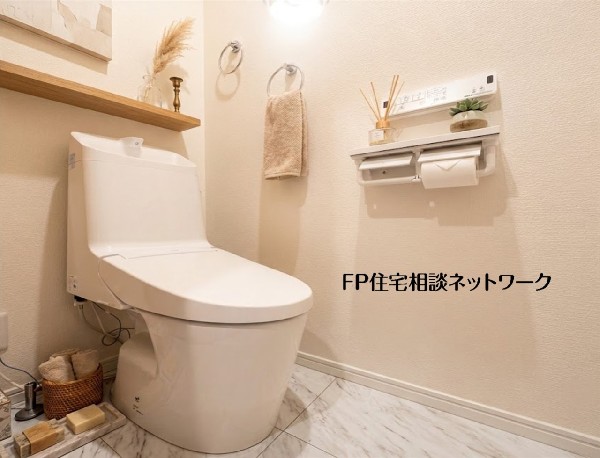 【トイレ】  清潔感に満ちた白を基調としたトイレです。多機能な温水洗浄便座のリモコンが壁に設置され、ペーパーホルダーも複数用意。床は大理石調で高級感があり、快適な空間です。 