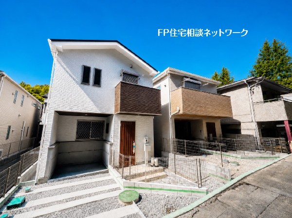 外観:【外観】  落ち着いた住環境が広がる閑静な住宅街。白を基調とした明るい外観と、バルコニーの木目調アクセントが映える、洗練された佇まいの新築戸建。穏やかな暮らしを叶える住まいです。