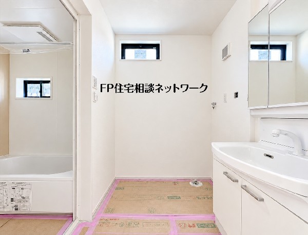 洗面台と洗濯機置き場をまとめた、明るい洗面脱衣室。浴室へつながる配置で、洗濯や入浴前後の身支度を一か所で行える空間です。