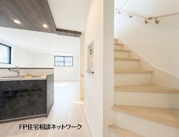 【キッチン│リビングイン階段】  キッチンからリビングへと視線が広がる、明るく開放的な空間。家族との会話を楽しみながら家事ができ、階段を通じて自然と顔を合わせやすい、温かな暮らしを育む設計です。