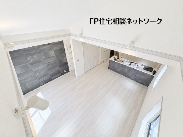 【吹抜け】  白を基調とした明るく開放的なリビングです。壁面やキッチンにダークカラーを採用し、スタイリッシュな空間に仕上げました。広々としたお部屋で、ご家族とゆったりとした時間を過ごせます。