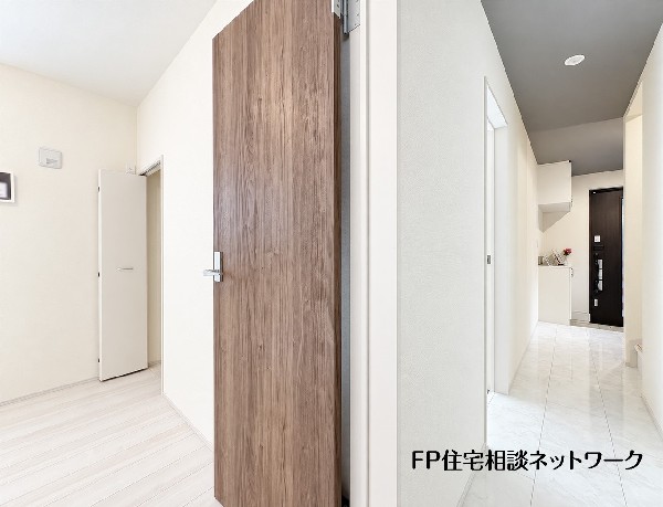 【1階廊下】  白を基調とした明るい廊下に、木目調の建具が温かみを添えます。床には高級感のある大理石調のフローリングが採用されており、家全体がすっきりと洗練された上品な雰囲気に仕上がっています。