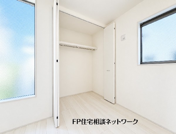 【クローゼット】  ２面の窓から自然光がたっぷりと差し込む明るい収納空間です。ハンガーパイプと上部棚が備え付けられた使い勝手の良い造りで、丈の長い衣類から小物類まで、用途に合わせて綺麗に整理できます。