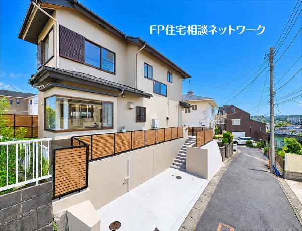 外観:【外観】  道路より一段高い敷地に建つ、落ち着いた外観の２階建て住宅。木目調のフェンスが外まわりを彩り、統一感を演出します。