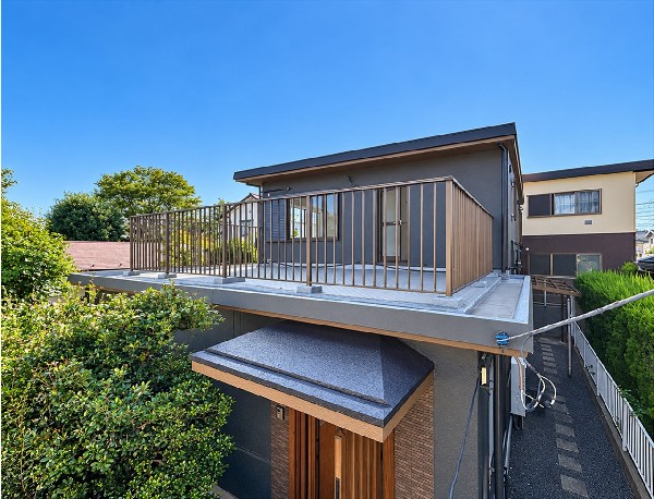 外観:落ち着いた色合いの外壁と木目調の玄関が印象的な住まい。バルコニーでは周囲の緑を眺めながら、青空の下で気分転換の時間を楽しめます。