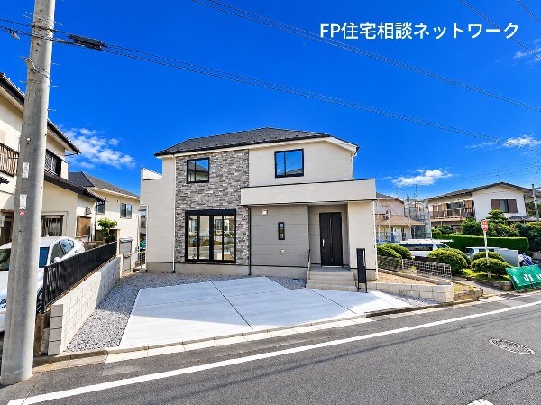 外観:【外観】  広々とした前面道路とゆとりあるカースペース。青空が広がる開放感と、第一種低層住居専用地域ならではの穏やかな街並みが魅力の邸宅。