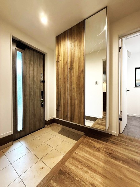 天井までの玄関収納付で、家族の履物が多くても安心。出勤前の身支度チェックに欠かせない姿見付です。