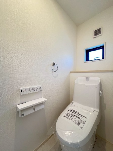 窓があるので陽ざしが入り明るいトイレ。洗浄機能付き便座を標準装備しています。1階と2階にあります。