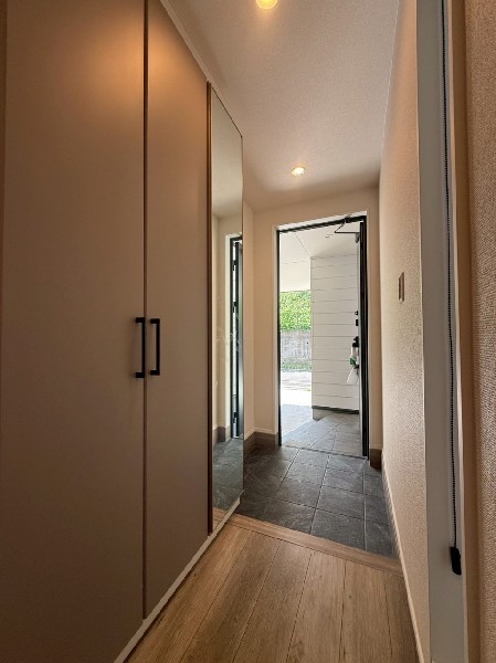 玄関収納をホールに設置し、タタキを広くしています。タタキに降りる前に靴を選べる配置です。大きな姿見付。