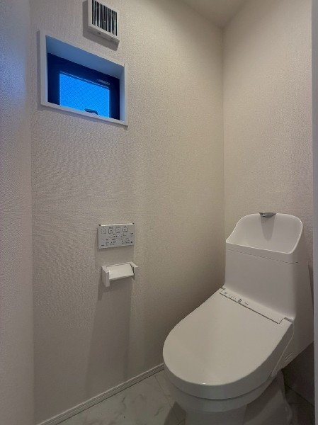 窓があるので陽ざしが入り明るいトイレ。洗浄機能付き便座を標準装備しています。1階と2階にあります。