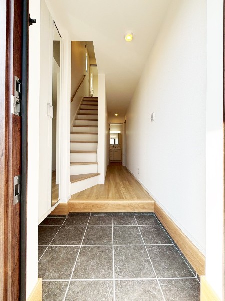 窓から自然光が射し込み訪れる人を心地よく迎え入れる玄関。天井までの大型玄関収納がありすっきり片付きます。