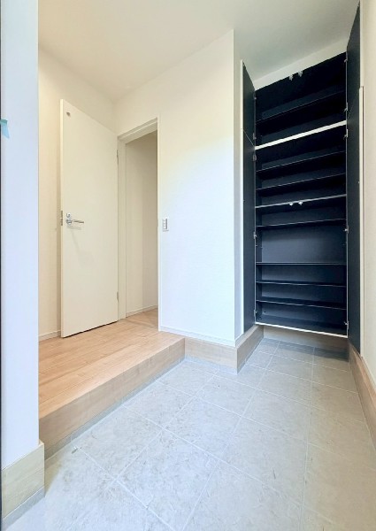 天井までの玄関収納付で、家族の履物が多くても安心。出勤前の身支度チェックに欠かせない姿見付です。