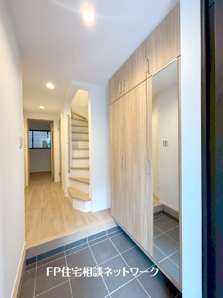 天井までの玄関収納付で、家族の履物が多くても安心。出勤前の身支度チェックに欠かせない姿見付です。